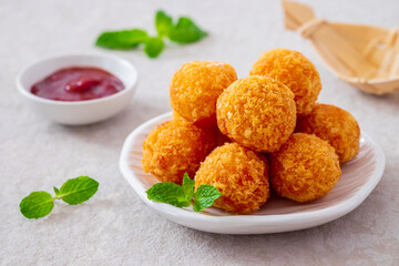 Deep fried cheese balls on plate and ketchup