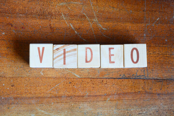 Photo of words with wooden block objects arranged into the word "VIDEO" in English