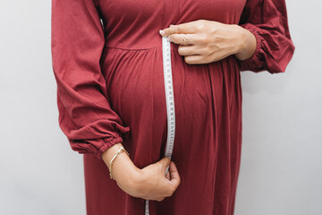 Muslim pregnant woman measuring her fundus belly stomach