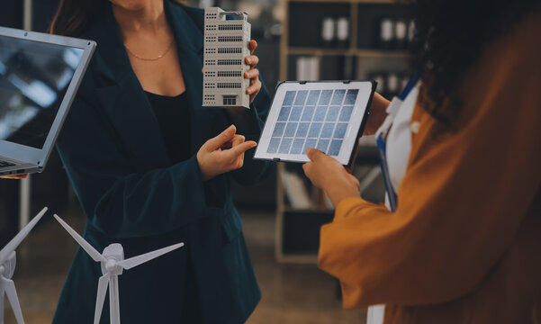 Electrical Engineer With Businessman Discussing New Project Installation Solar Cell Panel On The Roof Of Building. Alternative Energy Concept.