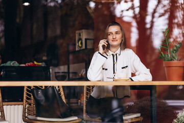 Woman sitting in coffee shop using mobile phone