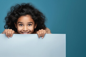 little indian girl behind a blank poster - obrazy, fototapety, plakaty