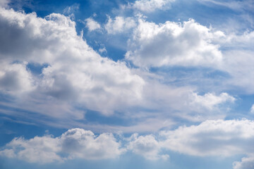 Blue sky with puffy cumulus cloud formations, natural background