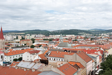 Fototapeta na wymiar Old historical center of Košice, Slovakia. European city landscape with authentic buildings with red roofs, cloudy sky and mountains on horizon, aerial view