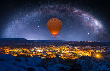 Hot air balloon flying over spectacular Cappadocia Milky Way galaxy in the background - Göreme,...