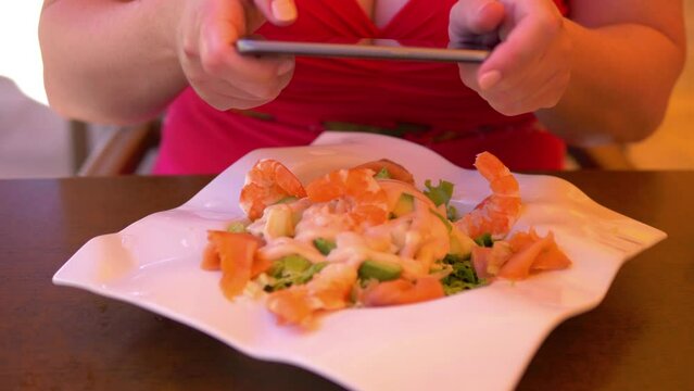 Woman taking picture of her lunch at the reastaurant in 4k slow motion 60fps