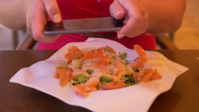Woman taking picture of her lunch at the reastaurant in 4k slow motion 60fps