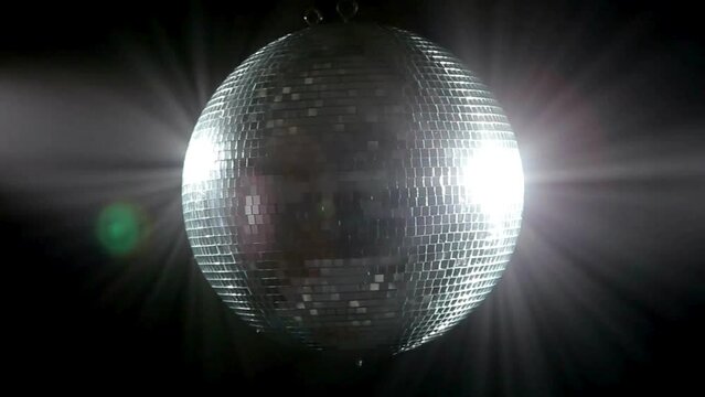 Close up disco ball against a dark background. Disco ball reflection light at night. Disco party balls on ceiling in a nightclub room. Close up of sparkly silver disco balls. Party concept.