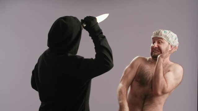 A maniac with a knife pulls back the shower curtain, intending to attack a man washing himself. A halfnaked man in a waterproof cap fights off the maniac, drives him away, closing the shower curtain.