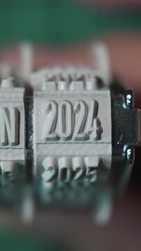 Vertical video of Changing the years on the rubber stamp from 2023 to 2024 to 2025 to 2026 to 2027 to 2028 to 2029 to 2030.