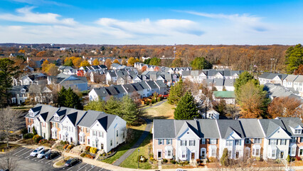 Drone Aerial Street and Rooftop View of Small Town Community Housing in Fall with Blue Sky's and...