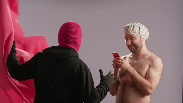 A maniac in a pink ski mask attacks a naked man with a phone in the shower. A masked and gloved killer strangles his victim while wearing a waterproof cap.