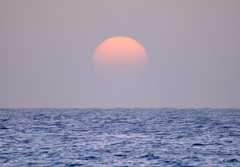 Beautiful sunset at the ocean during calima on the Canary Island Fuerteventura, Spain.