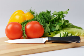 Chopping board with tomato, parsley and knife