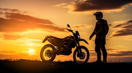 Obraz na płótnie Canvas silhouette of a male motorcyclist at sunset and an off-road enduro cross-country motorcycle.