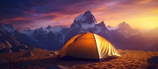 The dome tent is illuminated by the warm light of the rising sun as the golden cloudscape reveals dramatic mountain peaks from a panoramic landscape with blue, purple and orange skies - obrazy, fototapety, plakaty