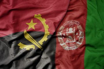 big waving national colorful flag of afghanistan and national flag of angola .