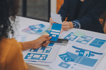 Close up ux developer and ui designer use augmented reality brainstorming about mobile app interface wireframe design on desk at modern office.Creative digital development agency