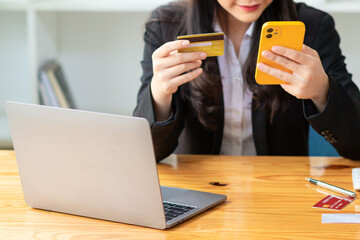 Young woman is shopping online through mobile application by paying with her credit card Convenience of paying through shopping online. Concept of online shopping and spending through credit card.