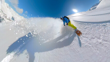 SELFIE, LENS FLARE: Adventurous snowboarder rides fresh snow on untracked slope
