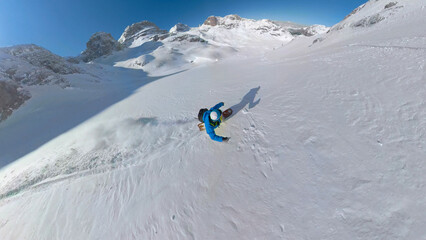 SELFIE, LENS FLARE: Adventurous snowboarder rides fresh snow on untracked slope