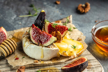 camembert cheese baked with figs, nuts and honey, place for text, top view