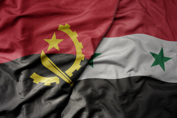 big waving national colorful flag of syria and national flag of angola .
