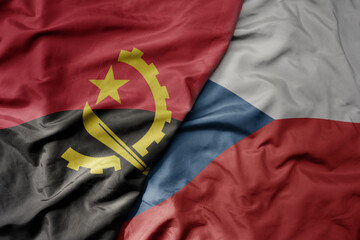 big waving national colorful flag of czech republic and national flag of angola .