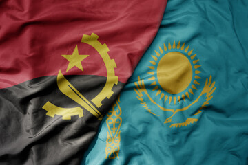 big waving national colorful flag of kazakhstan and national flag of angola .