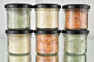 Stacked glasses with spices and herb salt on mirror
