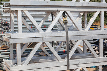 Disassembled aluminum scaffolding, stacked and secured on site.
