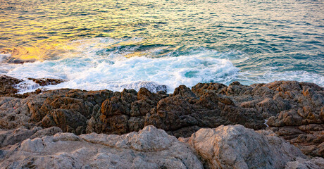 Obraz premium Ocean waves hit the rocky shore.