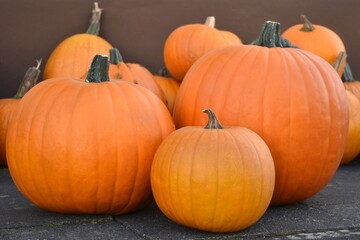 Orange halloween pumpkins in different sizes on pavement