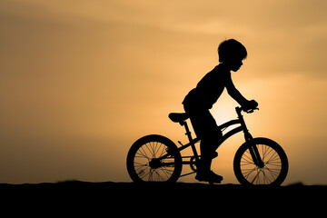 Obraz premium Silhouette boy riding bike at sunset in countryside. Small child outdoor. Sport time. Generative AI