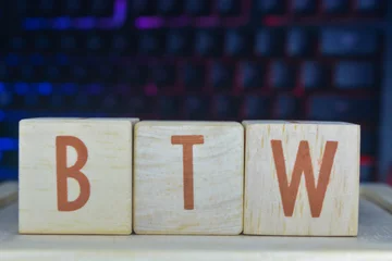 Fotobehang Photo of words with wooden block objects arranged into the word "BTW" in English © Ayudia