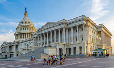 Kapitol in Washington D.C. mit Fahrradfahrern kurz vor Sonnenuntergang - obrazy, fototapety, plakaty