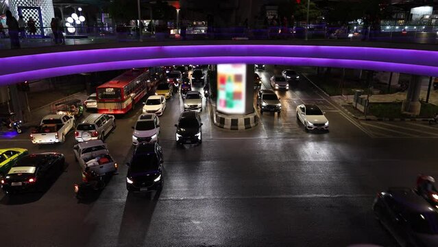 road under a pedestrian bridge with people. traffic of cars and people. Bangkok, Thailand