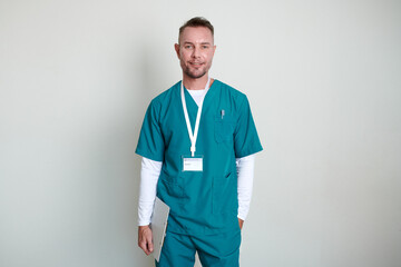 Portrait of smiling mature physiotherapist with clipboard standing against white wall