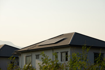 Sustainable Energy Solution: Solar Panels on House Rooftop Generating Clean Power in Urban Environment