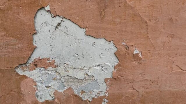 Peeling paint on the wall. Weathered rough painted surface with patterns of cracks and peeling. Wide panoramic grunge texture for background