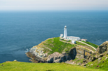 Fototapeta na wymiar South Stack lighthouse, on Anglesey, north Wales. The lighthouse is located on a small island just off the mainland and is reached by a flight of very steep stairs. It is a bright summers day