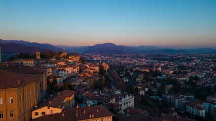 Fototapeta na wymiar Bergamo, Italy. Scenic aerial view of the old town city center Citta Alta. Landscape of the historical buildings during the sunset