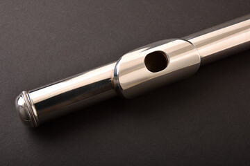 Detail of the head of metal flute on black table