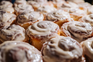 Amazing fresh baked cinnabon rolls buns with cream sauce. Sweet treat background