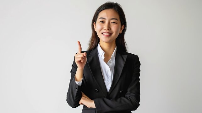 Successful upbeat smiling asian female manager, businesswoman in suit looking confident and pointing upper left corner with pleased grin