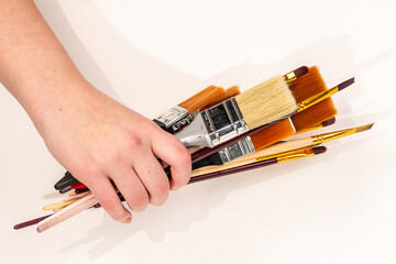 painting a wall, Different types of brushes held in a pot. Painting brushes in hand
