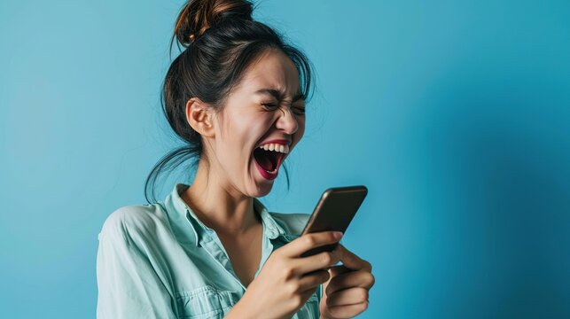 Woman Looking At The Phone Screen, Celebrating An Online Win, Overjoyed Young Asian Female Screaming With Joy