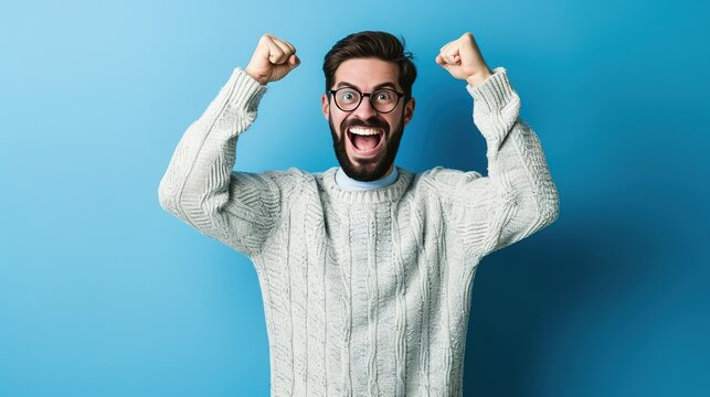 Young handsome man with beard wearing casual sweater and glasses over blue background very happy