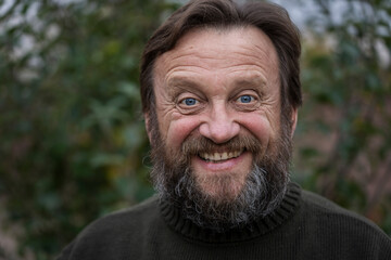 Portrait of a thinking or surprised senior man. Elderly bearded caucasian male in nature. Face bearded male dreams of solving issues