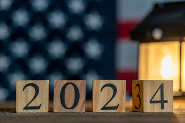 Starting new year 2024. Flipping of 2023 to 2024 on wooden cube blocks against the backdrop of the American flag. Inspiration to success ideas